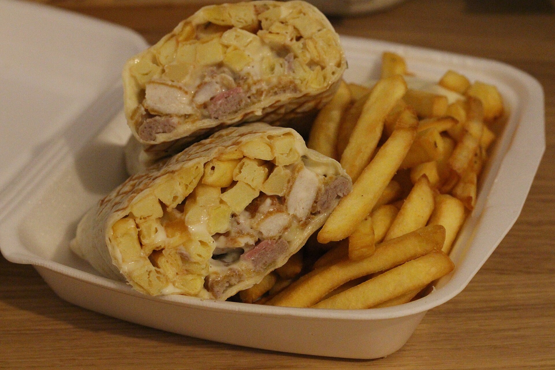 Tacos français garni de viande, frites et sauce fromagère